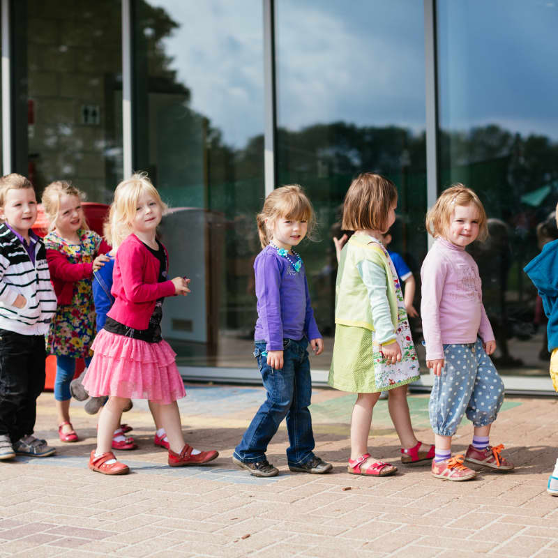 Kinderen staan in de rij op de speelplaats.