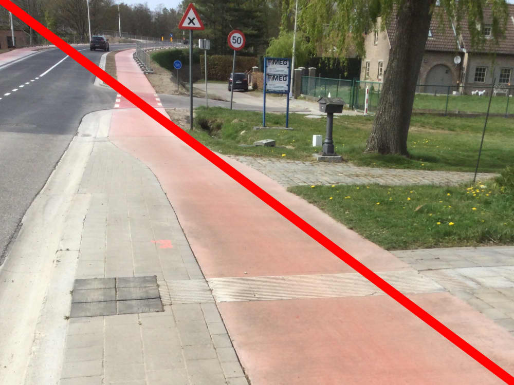 Een geleidelijn in ribbelstrook loopt zonder onderbreking door dwars over het fietspad. Een rode lijn geeft aan dat het zo niet moet.