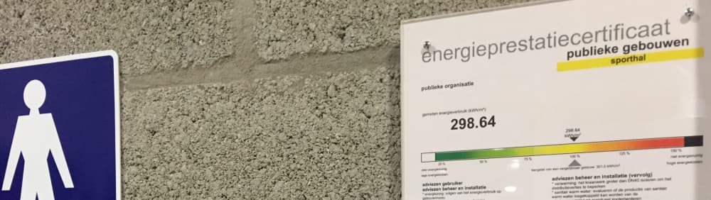 Een energieprestatiecertificaat voor publieke gebouwen aan een muur van een sporthal