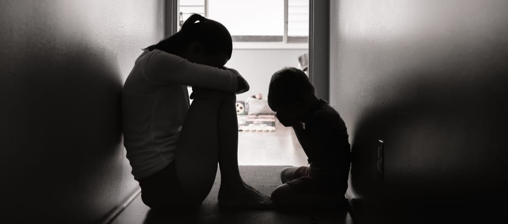 zwart wit foto van een huilende mama en kindje dat haar probeert te troosten