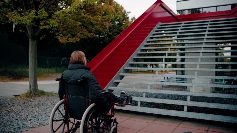 Meisje met gebroken been in rolstoel voor trap