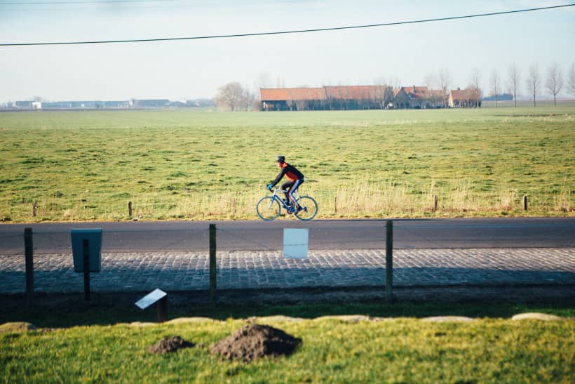 Fietser fietst tussen de polders.