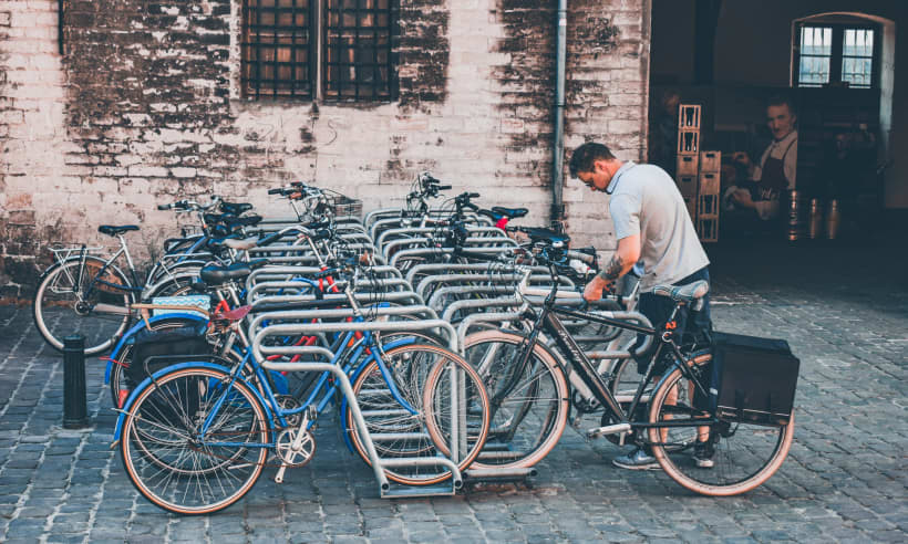 Een man zet zijn fiets weg in een fietsenstalling in het stad.