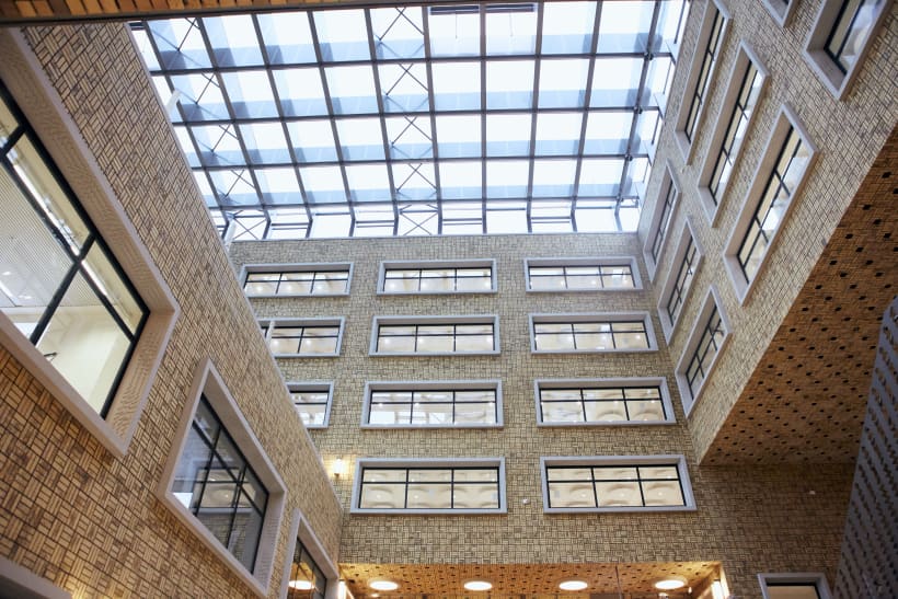Binnenkant van kantoorgebouw met glazen plafond en ramen van verschillende verdiepingen