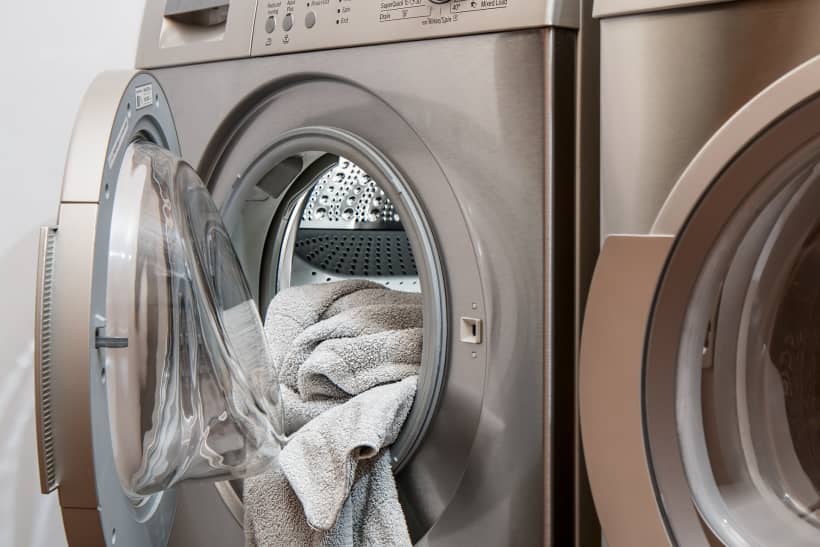 Een handdoek hangt uit de wasmachine.