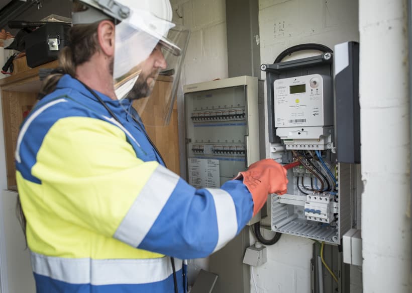 Een medewerker van netbedrijf Fluvius plaatst een nieuwe digitale meters voor elektriciteit en aardgas.