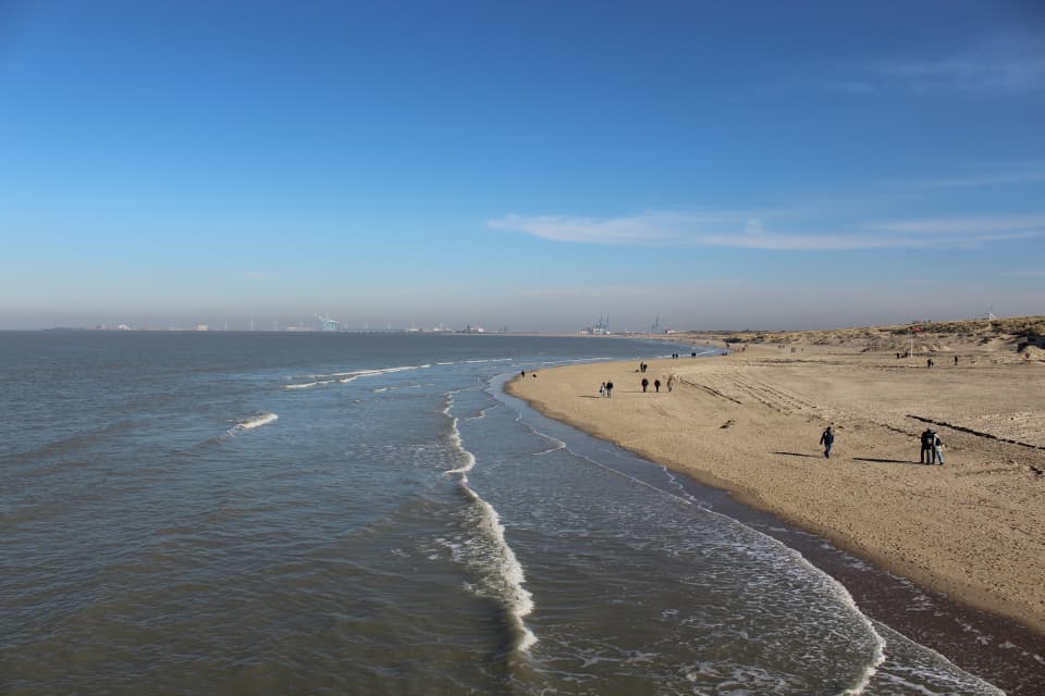 Zicht op de kust met wandelaars op het strand