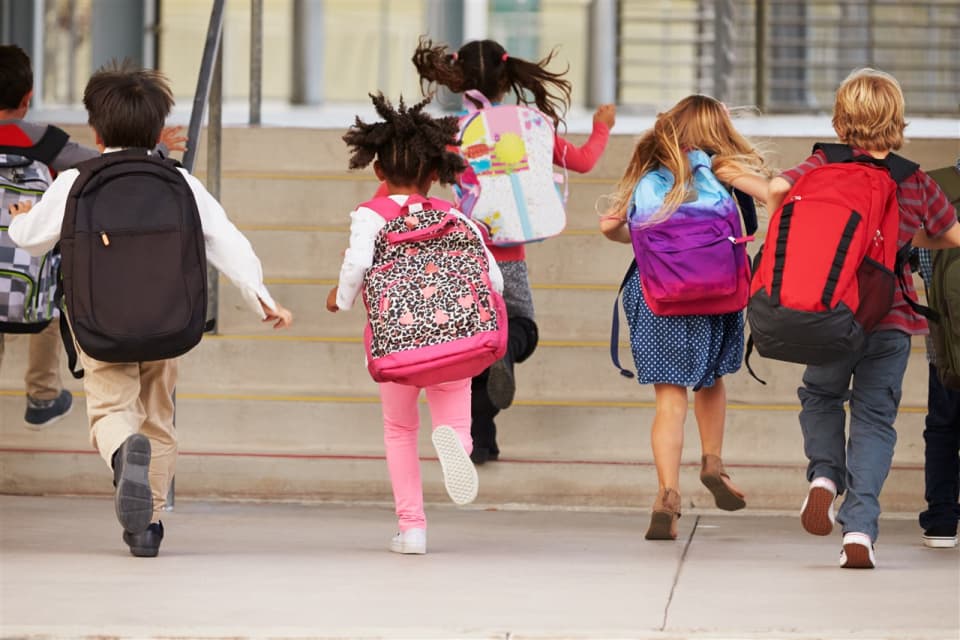 Kinderen met rugzak lopen naar school